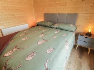 a bed with a green bedspread with rabbits on it at Alken The Stag in Bushmills