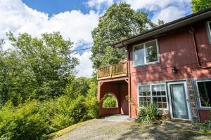 a red house with a balcony on the side of it at A Red Chalet in Newland