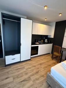 a kitchen with white cabinets and a large sliding door at Apartmenthaus Zeuthen 2 in Zeuthen