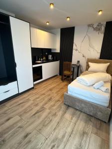 a bedroom with a bed and a kitchen at Apartmenthaus Zeuthen 2 in Zeuthen