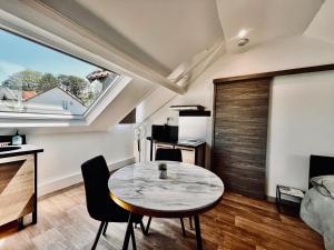 a living room with a table and a window at La Villa l'Oiseau Bleu proche de la plage et de Deauville !!! Awards 2025 in Blonville-sur-Mer