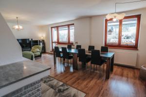 a dining room with a table and chairs at Apartmány s výhledem in Horní Maršov