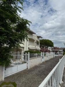 a white fence in front of a house at Appartamento ELDORADO in Lido di Pomposa