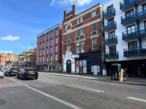 a city street with cars parked in front of buildings at Huge Modern 3 Bed Flat Central For Sightseeing in London