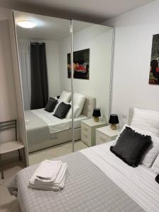 a bedroom with two beds and a large mirror at Appartamento ELDORADO in Lido di Pomposa