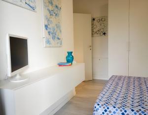 a bedroom with a bed and a tv on a white wall at Myama Lake in Desenzano del Garda +4 photos