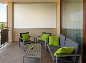 a living room with green pillows and a couch at Myama Lake in Desenzano del Garda