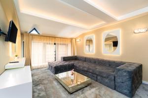 a living room with a large couch and a table at Tsarevets Boutique Hotel & SPA in Veliko Tŭrnovo
