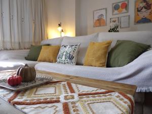 a living room with a couch with pillows and a table at La Castaña y la Uva in Ohanes