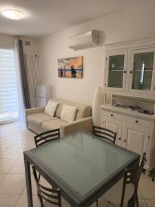 a living room with a couch and a table and chairs at Appartamento ELDORADO in Lido di Pomposa