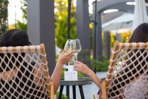 two women sitting in chairs holding a glass of wine at Row 7 Holiday Homes in Kyrenia