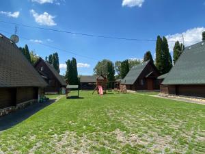 a large yard with houses and a playground at Őzike Apartmanházak in Bogács