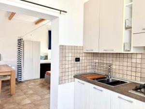 a kitchen with white cabinets and a sink at Casetta Rocca in Rocca San Giovanni