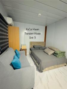 a bedroom with two beds and a sign on the wall at Kecai Haven Transient House in Digos