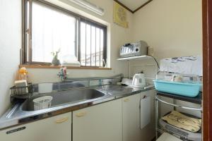 a kitchen with a sink and a window at ゲストハウス五郎平 in Nagahama