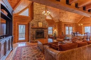 a living room with leather furniture and a fireplace at The Feisty Fox in Sugar Mountain