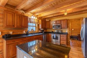 a kitchen with wooden cabinets and a granite counter top at The Feisty Fox in Sugar Mountain
