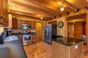 a kitchen with a stainless steel refrigerator and wooden cabinets at The Feisty Fox in Sugar Mountain +40 photos