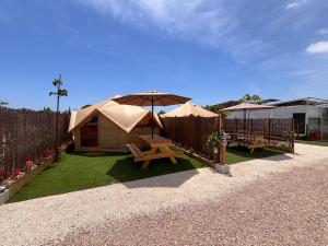 a backyard with two tents and a table and benches at Lomas de Balsares in Elche