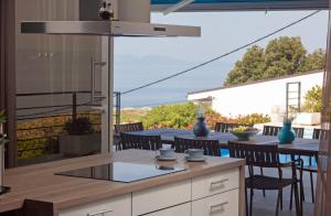 uma cozinha com uma mesa e cadeiras num pátio em Luxury Villa Mala Podgora em Podgora