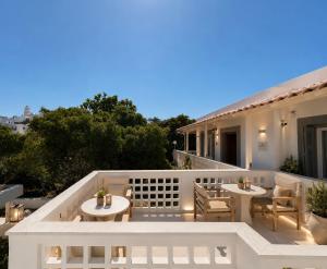 a balcony of a house with tables and chairs at Semiramis Hotel in Adamantas