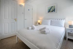 a bedroom with a white bed with towels on it at 1 Bed in St. Ives oc-pc466a in St Ives