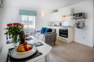 a kitchen and living room with a table with a bowl of fruit at 1 Bed in St. Ives oc-pc466a in St Ives +16 photos