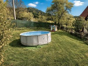 a bath tub sitting in the grass in a yard at Chatička Lukov in Lukov