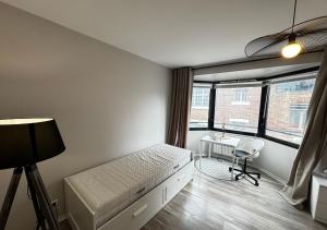 a bedroom with a bed and a desk and a window at Studio Horizon Amiens in Amiens