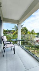 a balcony with a table and chairs and a view of the ocean at J C Apartment in Kingstown