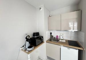 a small kitchen with a sink and a microwave at Studio Horizon Amiens in Amiens