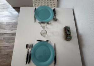 a table with a blue plate and utensils on it at Studio Horizon Amiens in Amiens
