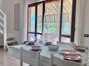 a dining room table with plates and wine glasses at Grace House in Marina di Sorso