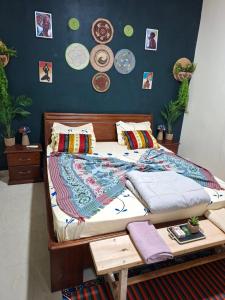 ein Bett in einem Schlafzimmer mit Tellern an der Wand in der Unterkunft Téranga Home Cosy & Spacieux à 600m de la plage in Dakar