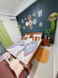 ein Schlafzimmer mit einem Bett und einer Wand mit Tellern in der Unterkunft Téranga Home Cosy & Spacieux à 600m de la plage in Dakar