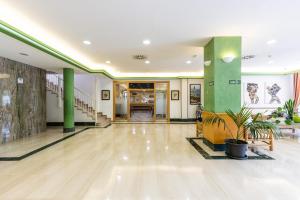 an empty lobby with green pillars and a staircase at Rentalmar Pineda Suites in La Pineda +115 photos