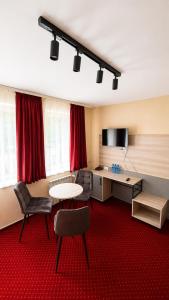 a room with a table and chairs and red carpet at Hotel Relaks in Wola Ducka