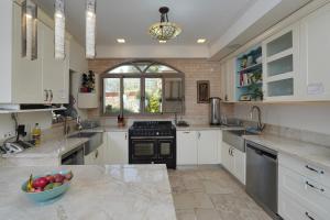 a kitchen with white cabinets and a bowl of fruit on the counter at Villa Netofa (Kosher) in Mitspe Netofa +28 photos