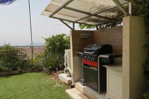 an outdoor kitchen with a stove and a pergola at Villa Netofa (Kosher) in Mitspe Netofa