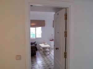 San Isidoro White Loft في إشبيلية: باب مفتوح لغرفة المعيشة مع طاولة