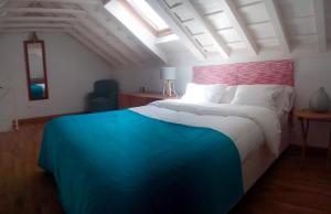San Isidoro White Loft في إشبيلية: غرفة نوم بسرير ازرق وبيض مع نافذة