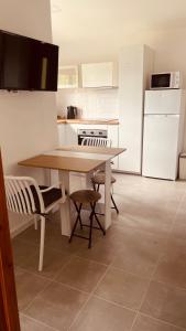 a kitchen with a table and chairs and a refrigerator at A Casinha in Ventuzelo