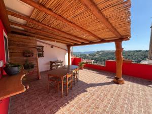 eine Terrasse mit Tisch und Stühlen auf einem Dach in der Unterkunft B&B Amistade in Seùlo