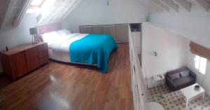 San Isidoro White Loft في إشبيلية: غرفة نوم صغيرة بسرير وارضية خشبية