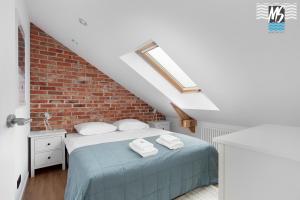a bedroom with a bed and a brick wall at Top Center VI in Gdynia