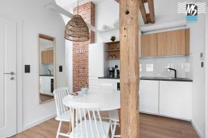 a kitchen and dining room with a white table and chairs at Top Center VI in Gdynia
