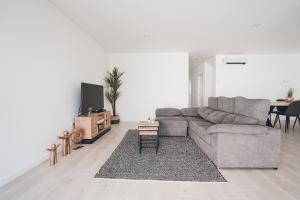 a living room with a couch and a table at Villa Delfina with private pool in Mariquiteira