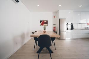 a kitchen and dining room with a table and chairs at Villa Delfina with private pool in Mariquiteira +13 photos