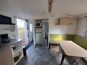 a small kitchen with a table and a dining room at Kabana Village in Saint-Hilaire-de-Riez