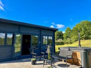 a blue tiny house with a grill and chairs at Black Cat House Radailiai in Radailiai